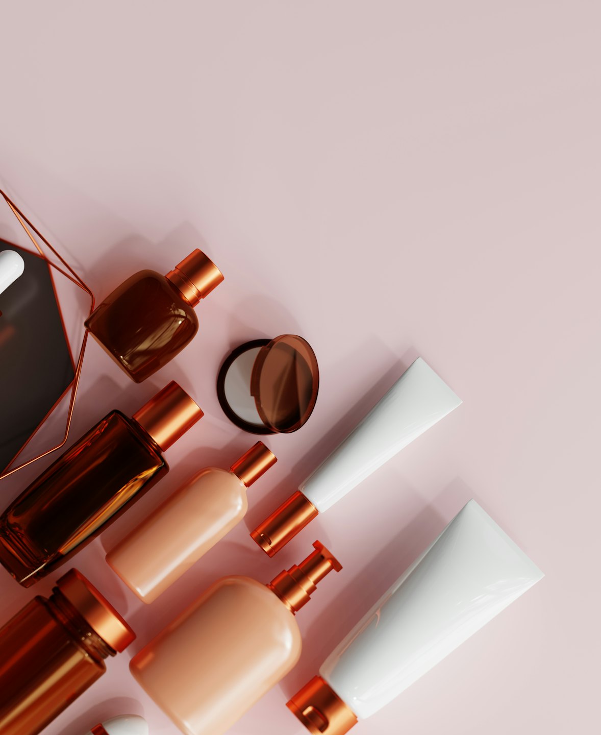 Productos de cosmética y cuidado de la piel dispuestos sobre un fondo rosa.