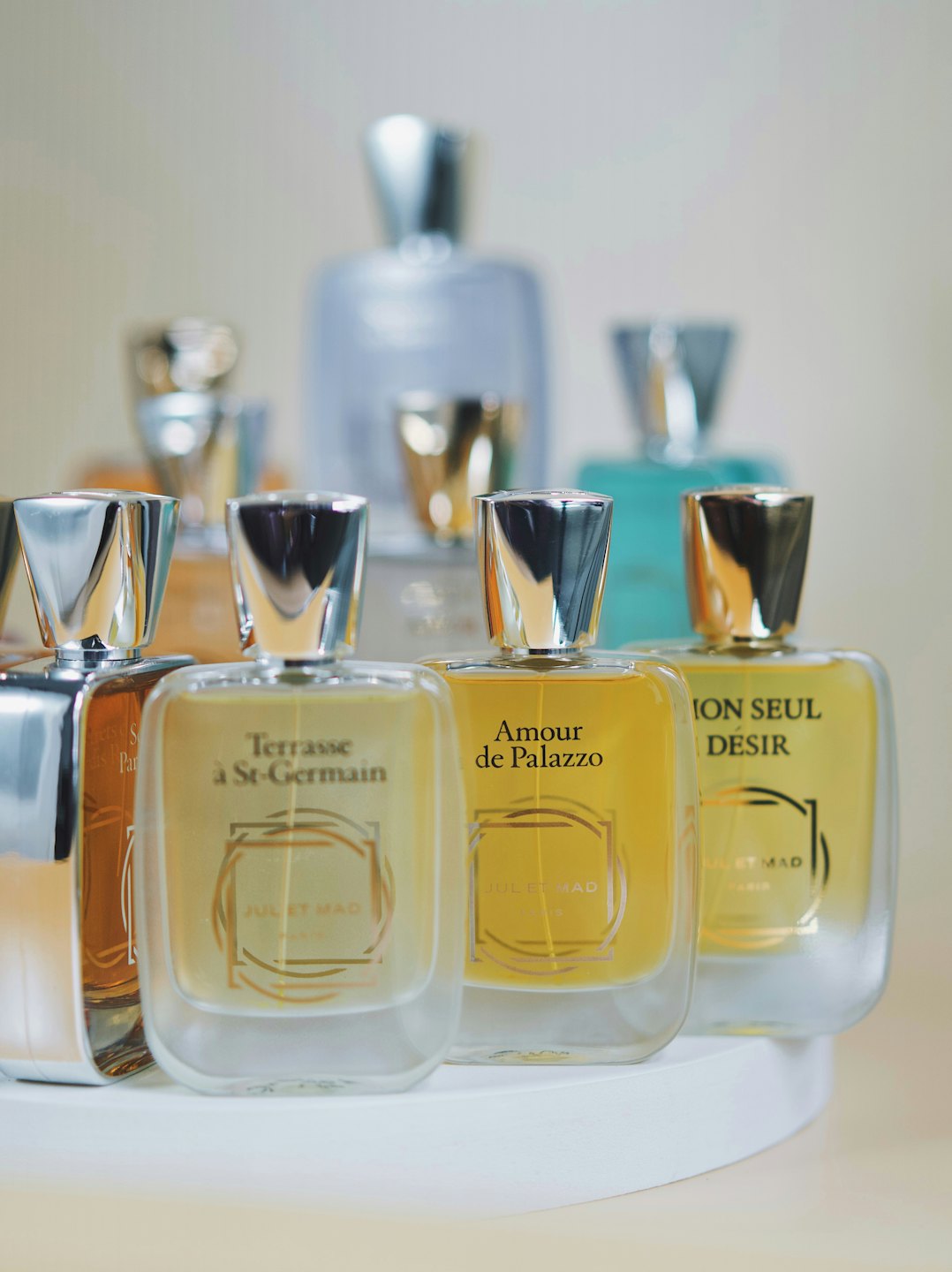 Frascos de perfume de lujo dispuestos en un expositor blanco.